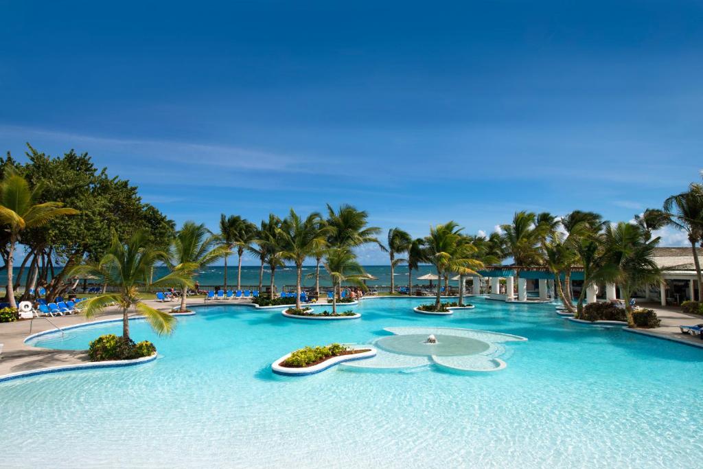 Coconut Bay Beach Resort & Spa All Inclusive في فيو فورت: منتجع فيه مسبح كبير فيه نخل