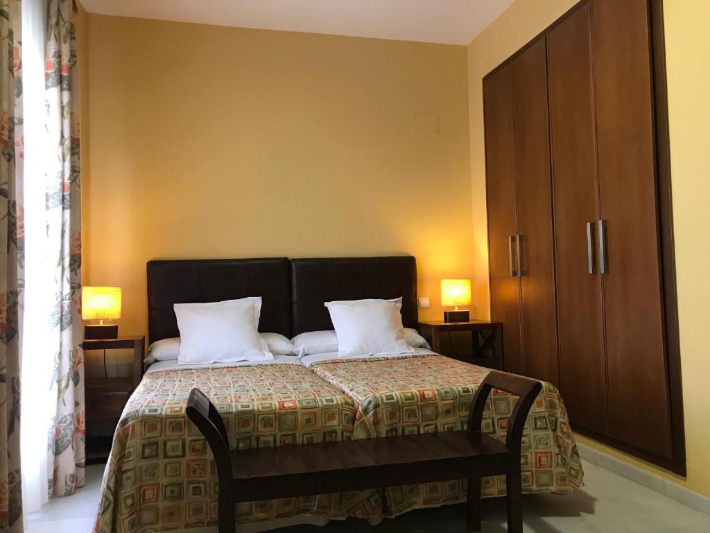 een slaapkamer met een bed met 2 kussens bij Hotel Lince in Aznalcázar