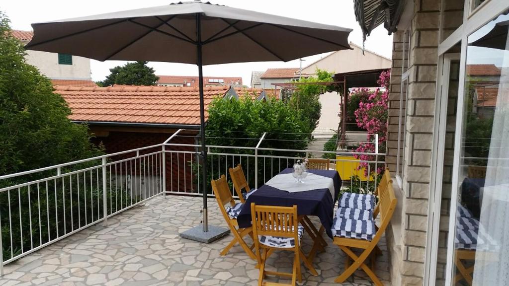 a table and chairs under an umbrella on a patio at Mali Šjor in Primošten