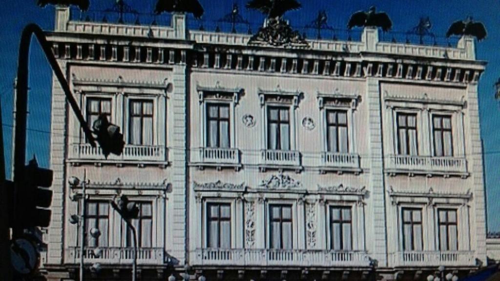 ein großes weißes Gebäude auf einer Straße mit Ampel in der Unterkunft Hotel Vitória in Rio de Janeiro