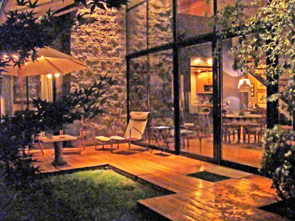un patio con una silla, una sombrilla y una mesa en Luxury house jacuzzi & garden - rental in Mendoza en Mendoza