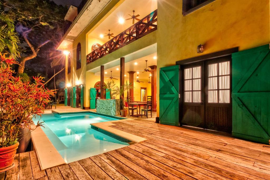 a house with a swimming pool and a wooden deck at Toucan Suite @ Mahogany Hall in San Ignacio