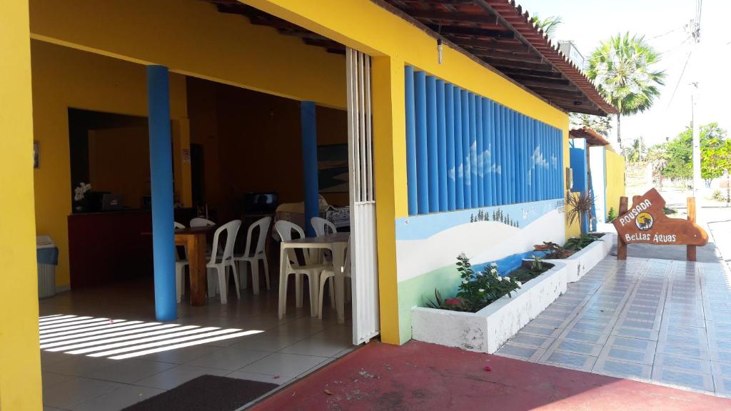 un edificio amarillo y azul con mesa y sillas en Pousada Reflexo das Águas, en Santo Amaro