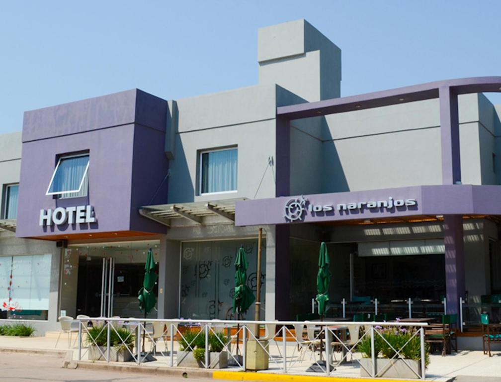a store front of a building with tables and chairs at Hotel Los Naranjos in General Deheza
