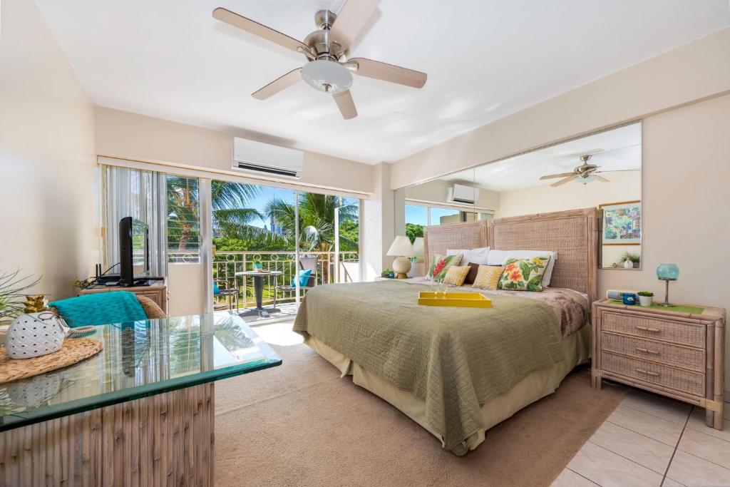 a bedroom with a bed and a glass table at Waikiki Shore 305 (beachfront/balcony) in Honolulu