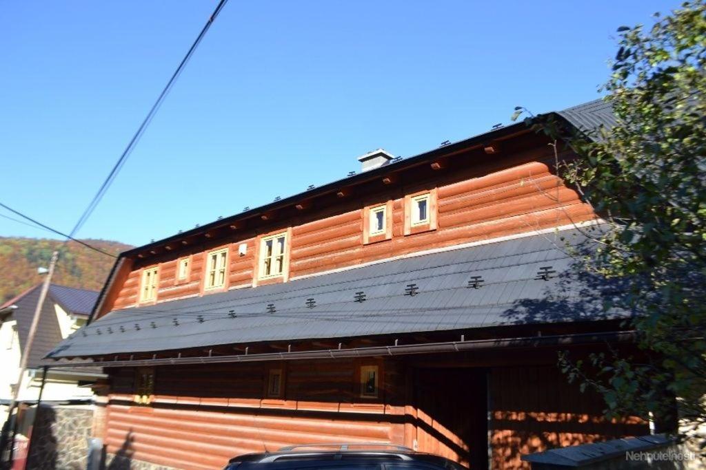 a large wooden house with a car parked in front of it at Chalupa JANINA in Terchová