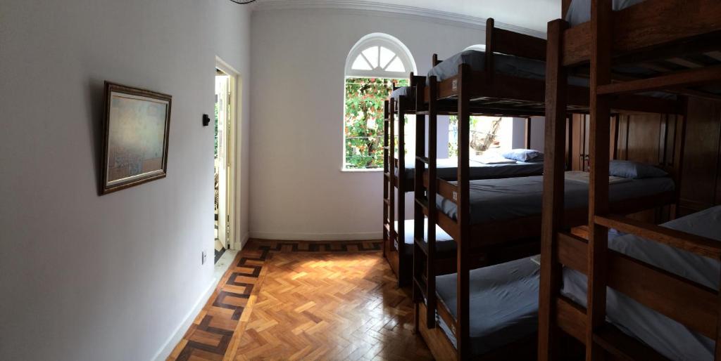 a room with three bunk beds and a window at Hostel Casarão 65 in Salvador