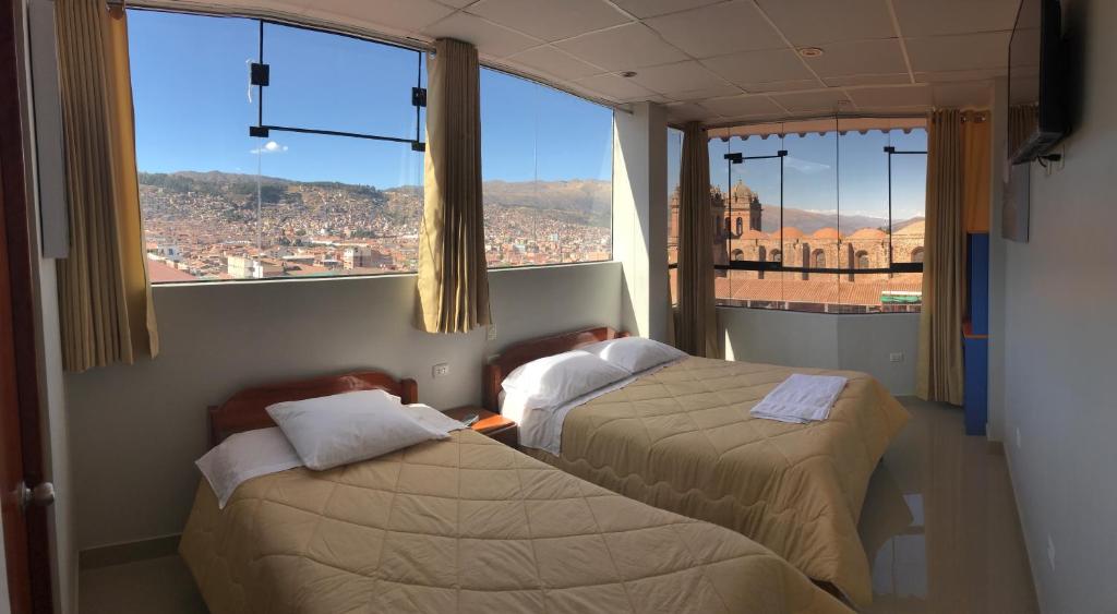 2 camas en una habitación con vistas a la ciudad en Edmoli Casa Hospedaje, en Cusco