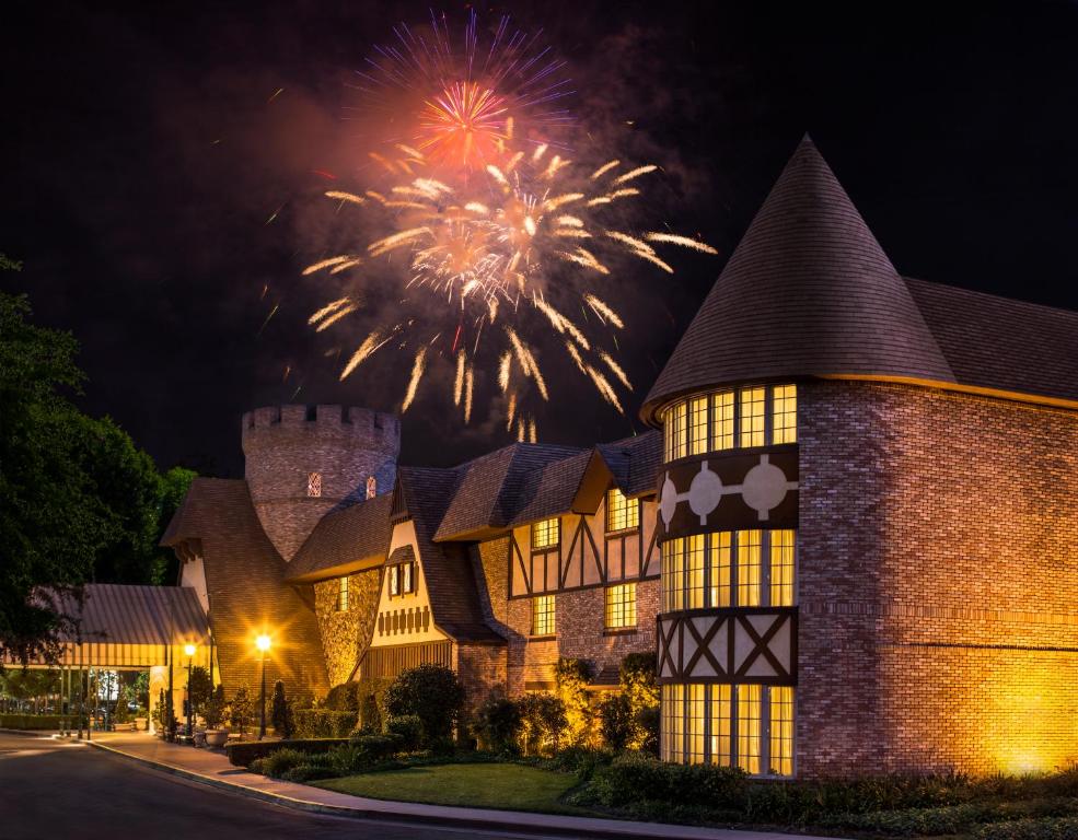 Una casa con fuochi d'artificio che esplode nel cielo dietro di essa di Anaheim Majestic Garden Hotel ad Anaheim