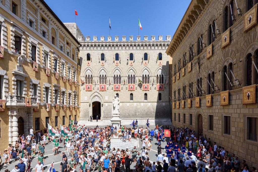 un grande gruppo di persone in piedi in un edificio di Domus Nannini SPA - Palazzo Nannini a Siena