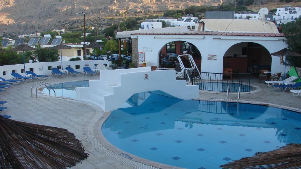 een zwembad in een hotel met uitzicht op de bergen bij Apostolis Hotel Apartments in Pefki Rhodes