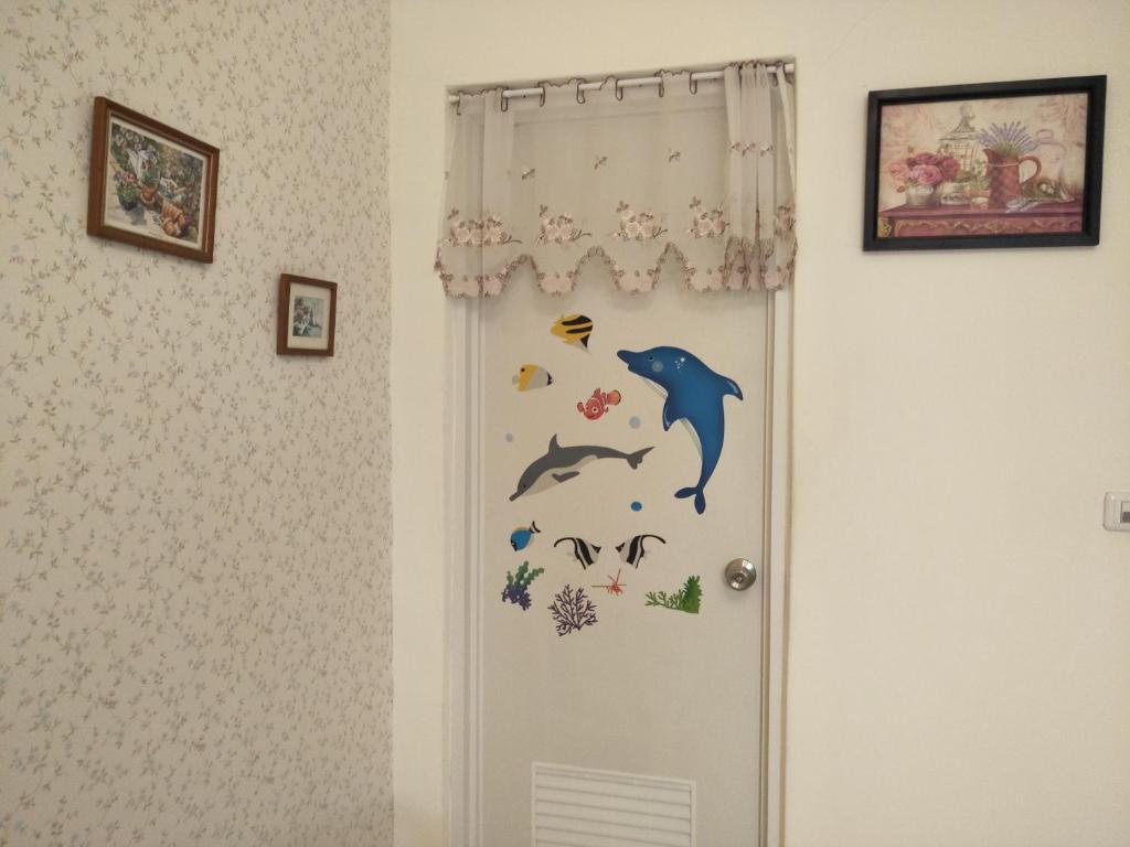 a door with a dolphin and fish stickers on it at 巧緣民宿11人包棟 in Hualien City