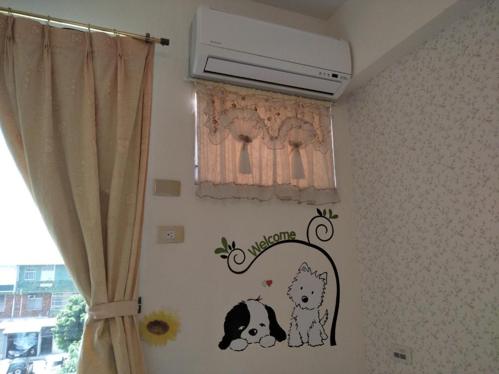a bedroom with a wall with a dog decal on it at 巧緣民宿11人包棟 in Hualien City