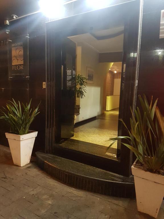 um corredor com dois vasos de plantas em frente a um edifício em Hotel Flor em São Paulo