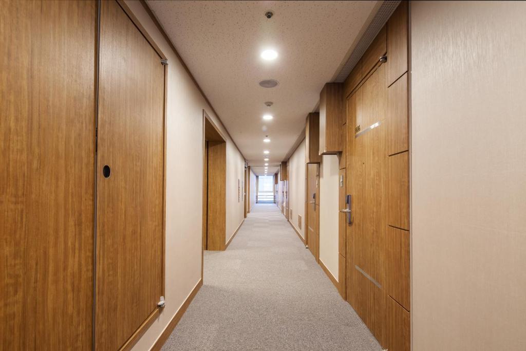 a long corridor with wooden doors and a hallway with a corridorngthngthngthngth at Western Coop Hotel & Residence Dongdaemun in Seoul