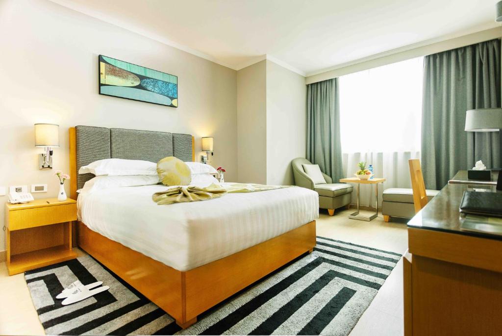 una camera d'albergo con un grande letto e un bagno di Ambassador Hotel ad Addis Abeba