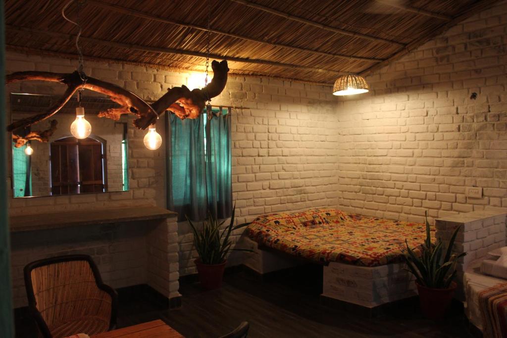 a room with a table and a brick wall at Shannu's Ranch Inn in Pushkar