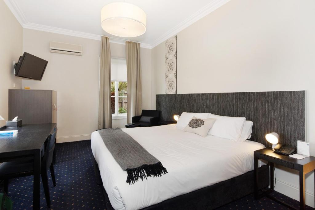 Habitación de hotel con cama y escritorio en Sovereign Hill Hotel, en Ballarat
