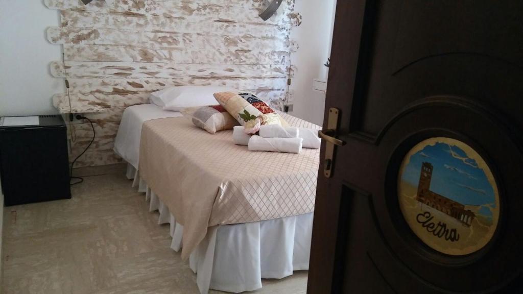 a bedroom with a bed and a stone wall at Bed and Breakfast Elettra in Marconia