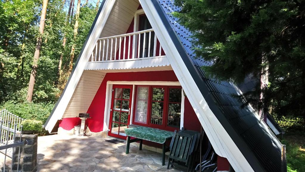 una casa con un porche con un banco delante en Finnhütte Rudolf, en Garitz