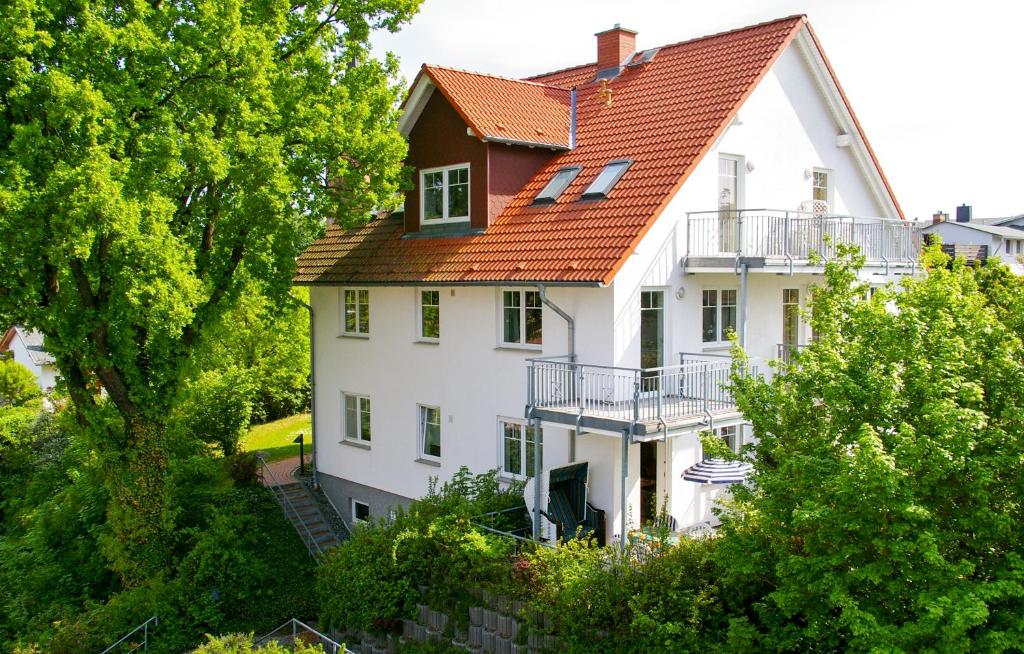 uma grande casa branca com um telhado laranja em Fewo Zinnowitz Ostseequartett em Zinnowitz
