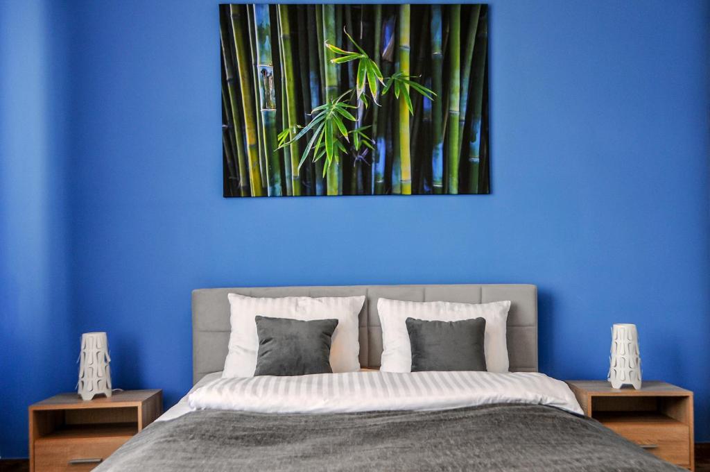 a blue bedroom with a bed with a blue wall at Mountain View in Krynica Zdrój