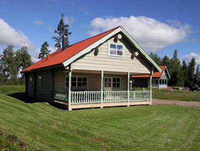 une petite maison avec un toit rouge sur un champ dans l'établissement Rensbo Stugor, à Hedemora