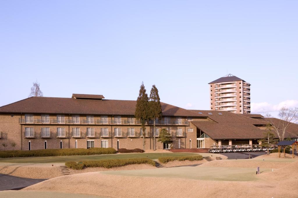 a large brick building with a tall building in the background at Hotel G-Style in Sayo