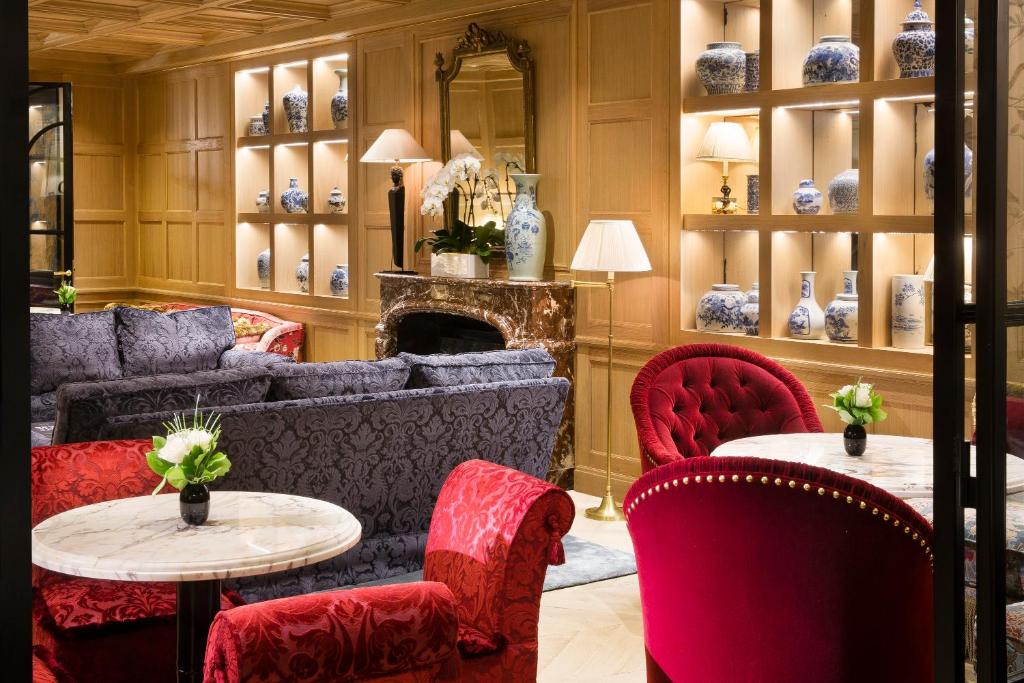 a living room with couches and tables and chairs at Relais Christine in Paris