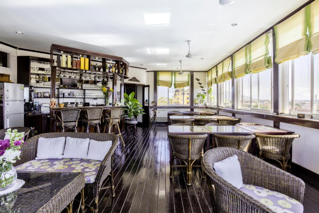 a restaurant with tables and chairs and windows at Résidence Sisouk in Pakse