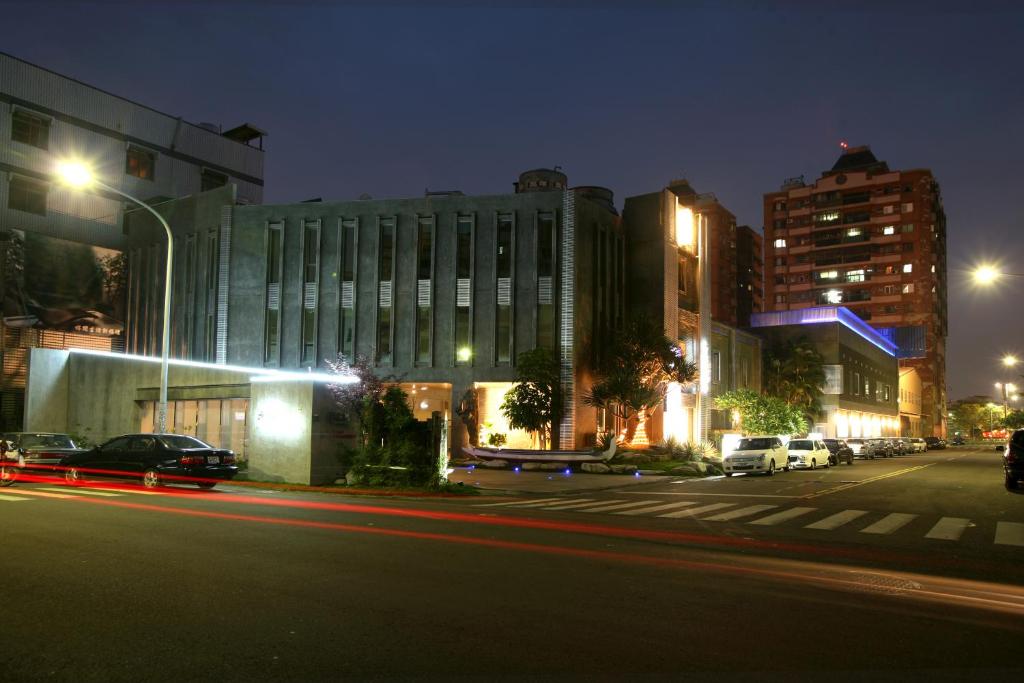 un edificio en una calle de la ciudad por la noche en Her Home Spa Motel Chiayi, en Chiayi