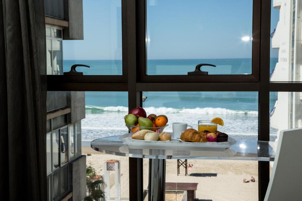 a plate of fruit on a table in front of a window at Hotel Spa Cádiz Plaza in Cádiz
