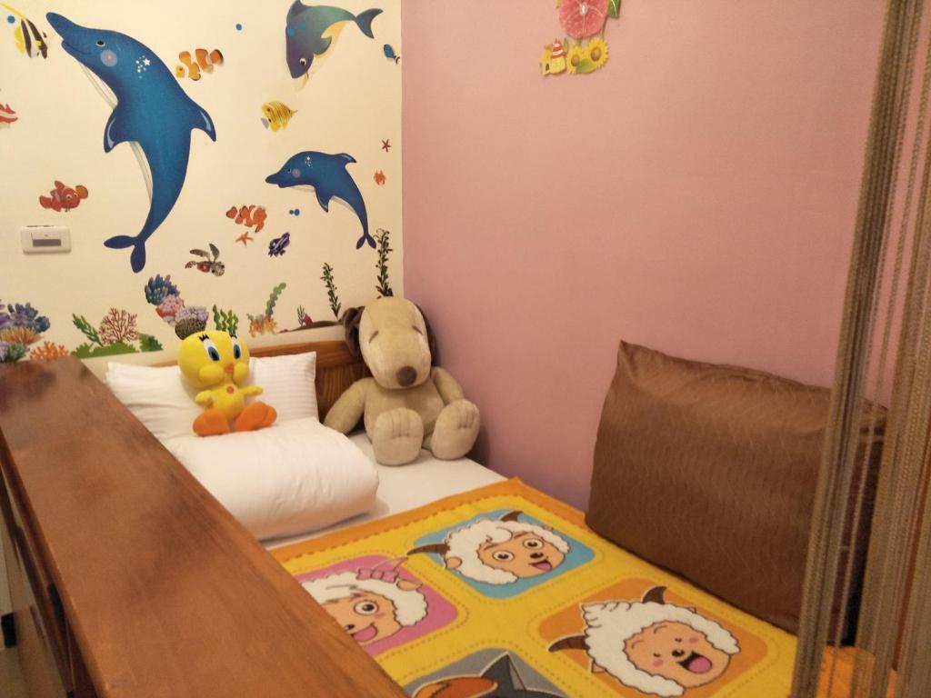 a bedroom with a bed with a teddy bear on it at 巧緣民宿11人包棟 in Hualien City