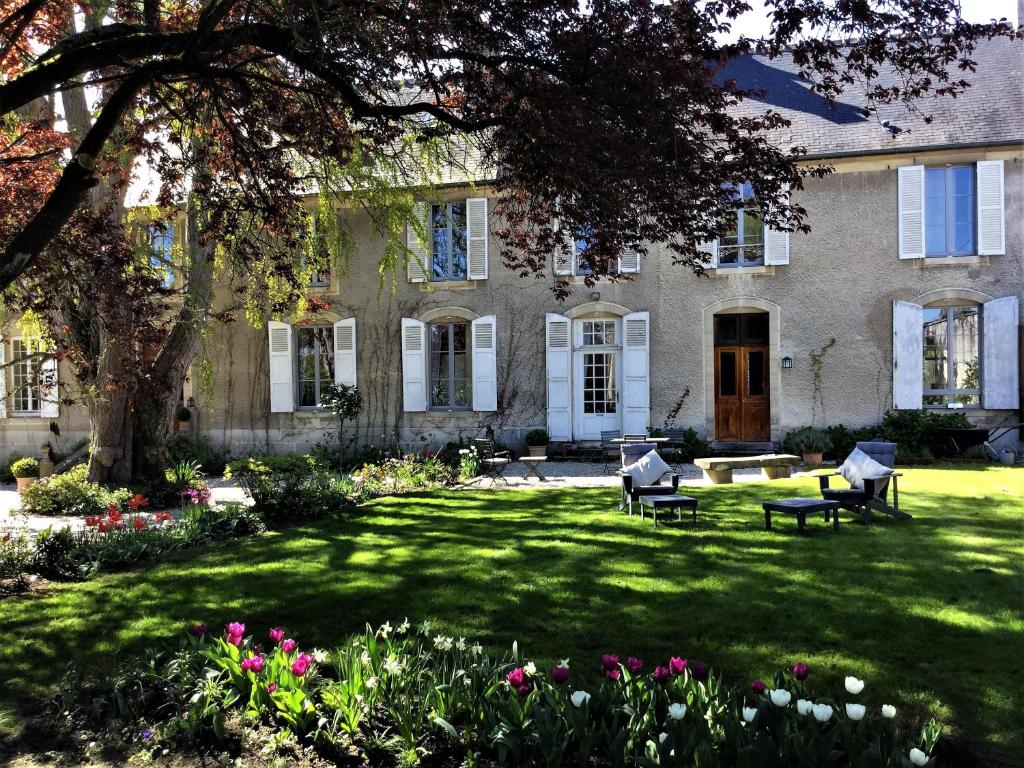 duży dom z ogródkiem z kwiatami w obiekcie Le Grand Arbre w mieście Bayeux