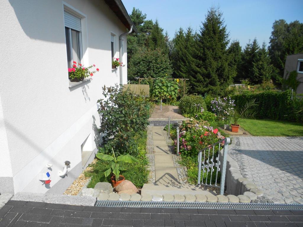 un jardin avec des fleurs et une clôture à l'extérieur d'une maison. dans l'établissement Crosta Brava, à Großdubrau