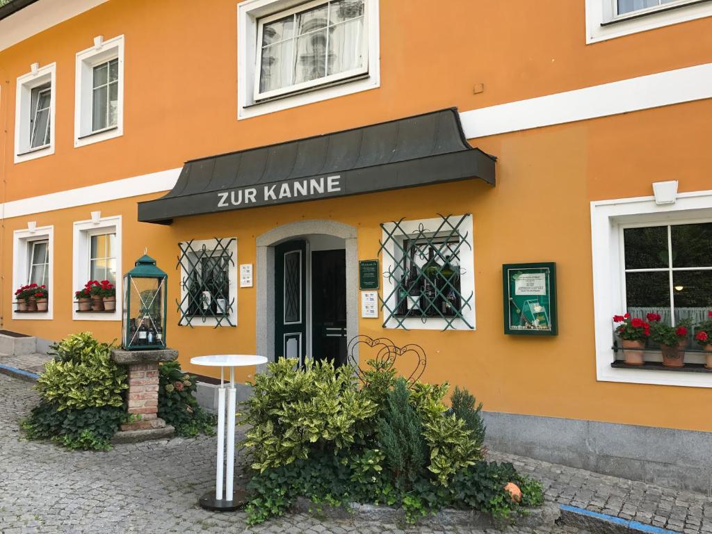 Markt Sankt FlorianにあるGasthof "Zur Kanne"の十念神明の看板のあるオレンジ色の建物