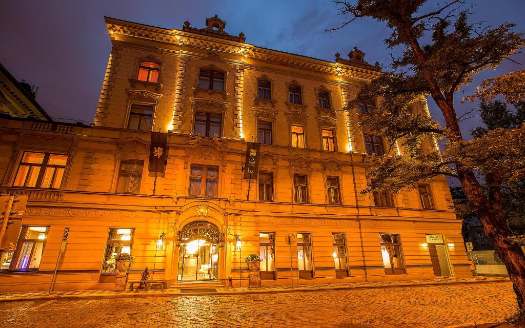 a large building with lights on it at night at Le Palais Art Hotel Prague in Prague