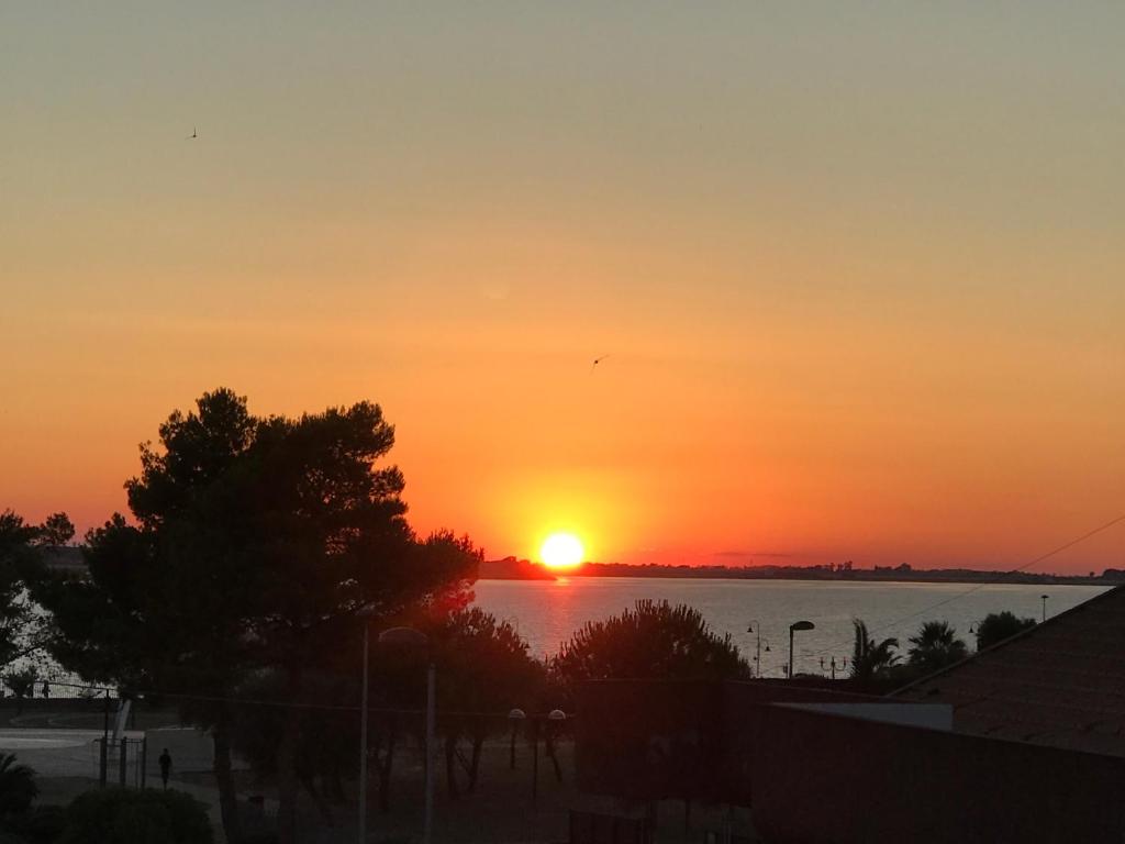a sunset over a body of water with the sun at Vista Lago Panorama in Lesina