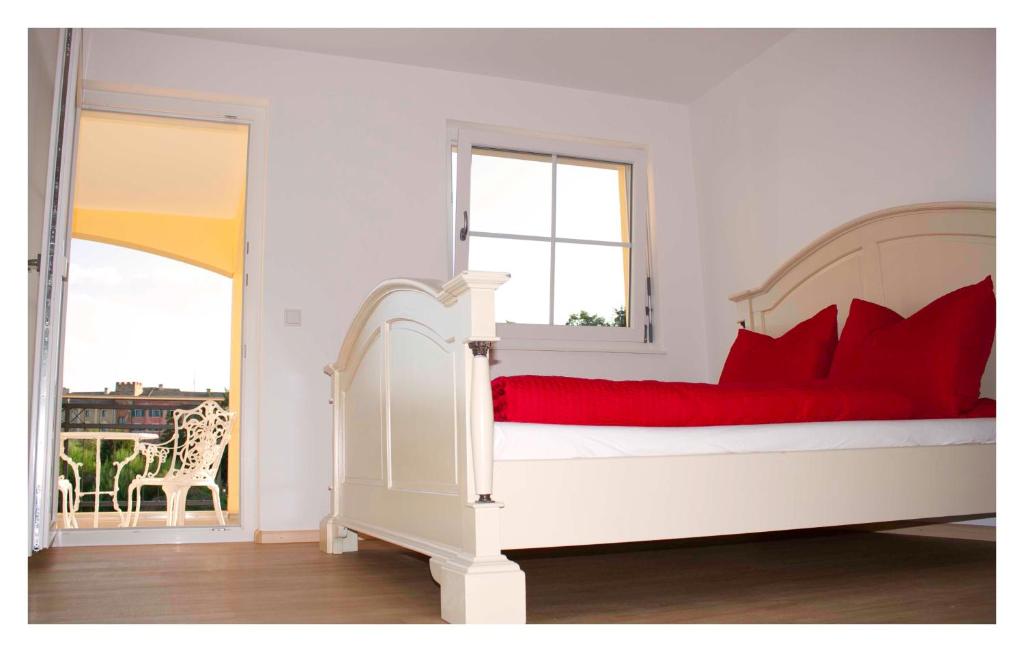 1 dormitorio con cama blanca y almohadas rojas en PETITE FRANCE Apartment - EP Ticket Garantie, en Rust