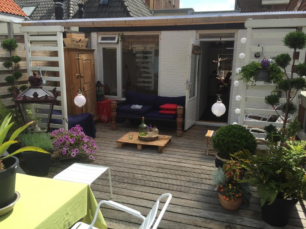 een patio met een blauwe bank en een aantal planten bij Roofterrace Apartment in Alkmaar