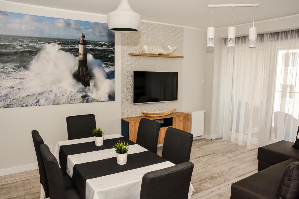 uma sala de jantar com uma mesa e uma televisão em Apartament 34 Gdynia KLIMATYZOWANY em Gdynia