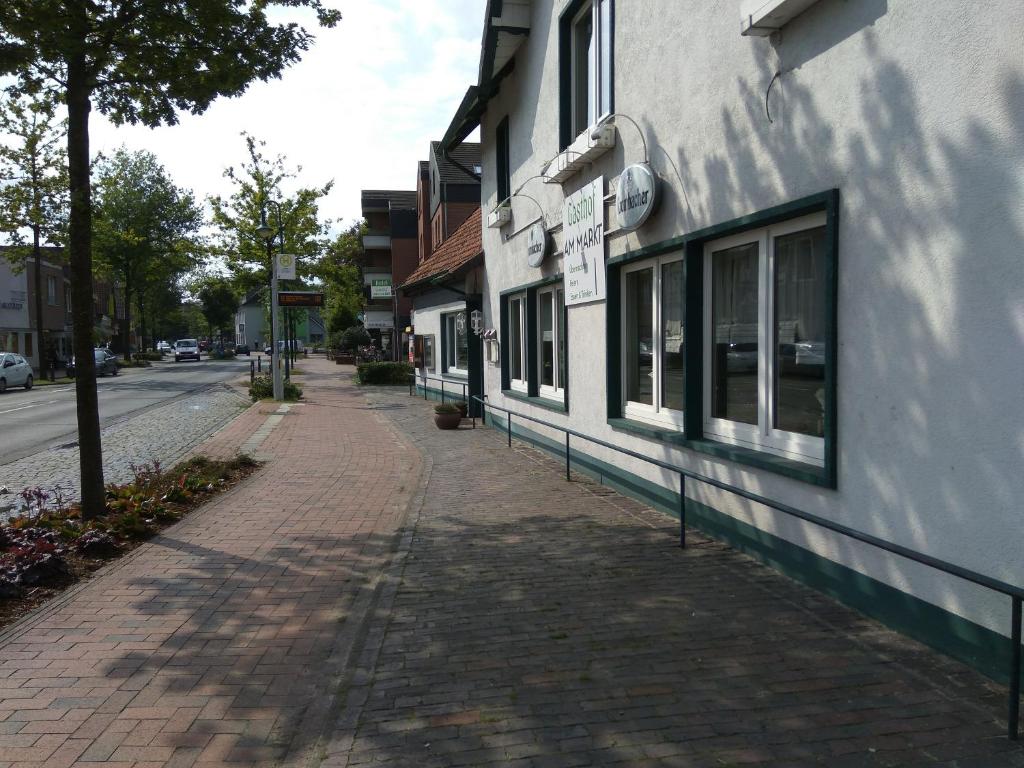 einen Backsteinsteig neben einem Gebäude auf einer Straße in der Unterkunft Gasthof am Markt in Edewecht