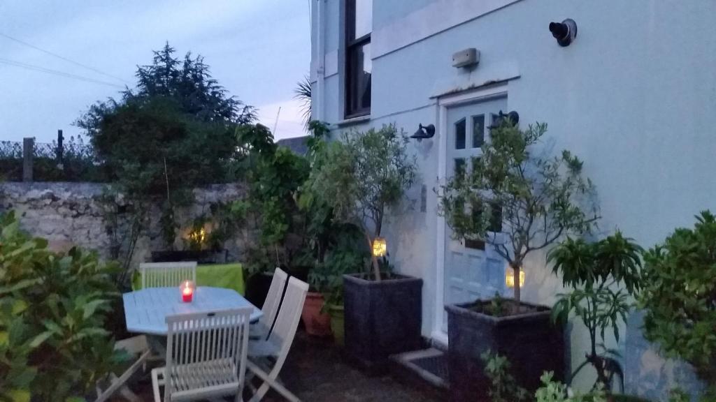 a patio with a table and chairs in front of a building at The Coach House in Plymouth