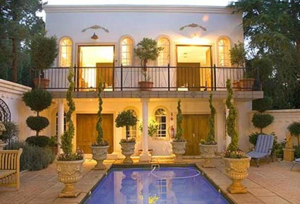 a large house with a swimming pool in front of it at Pheasant Hill Bed and Breakfast in Rietvalleirand