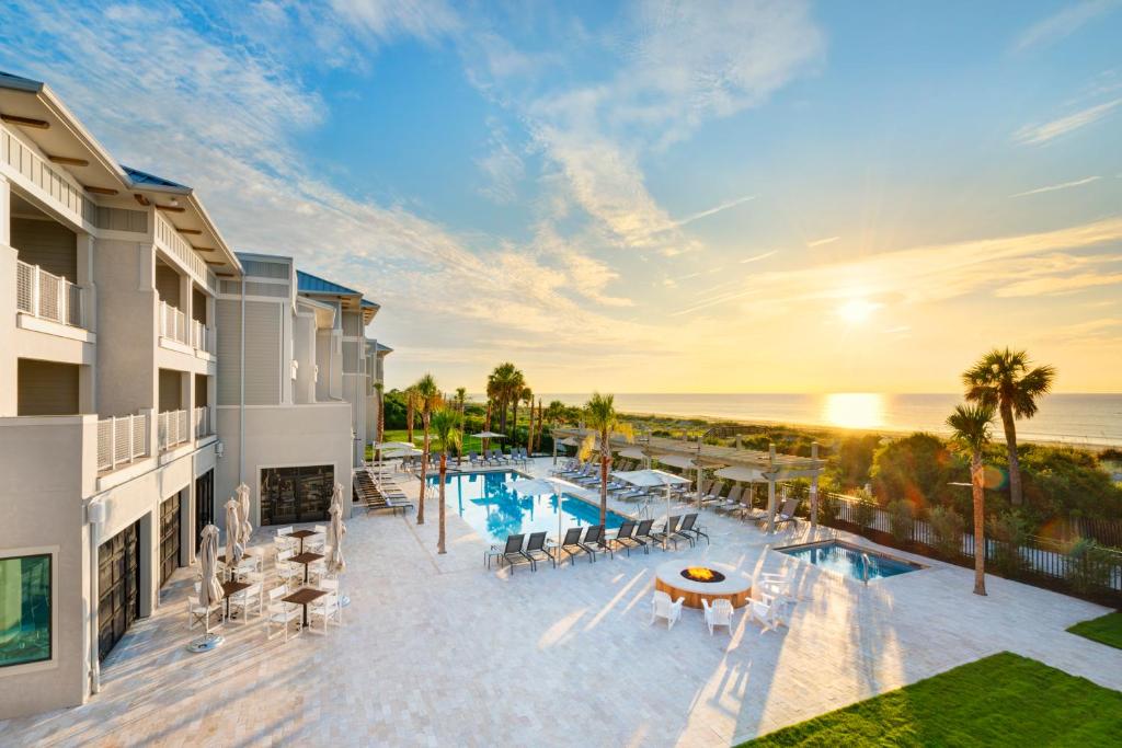 an aerial view of a resort with a pool and the ocean at Jekyll Ocean Club Resort in Jekyll Island