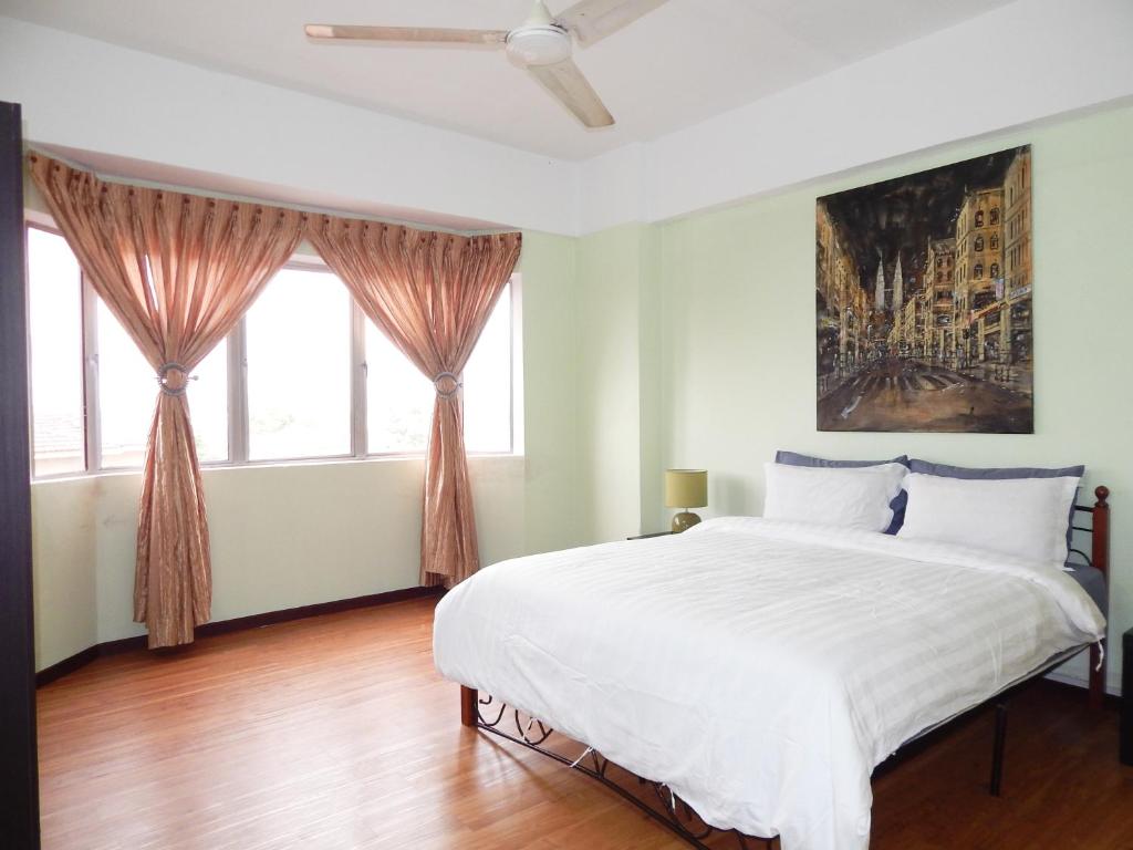 a bedroom with a large bed and two windows at Wadi Iman Guesthouse @ Sri Mahligai in Shah Alam