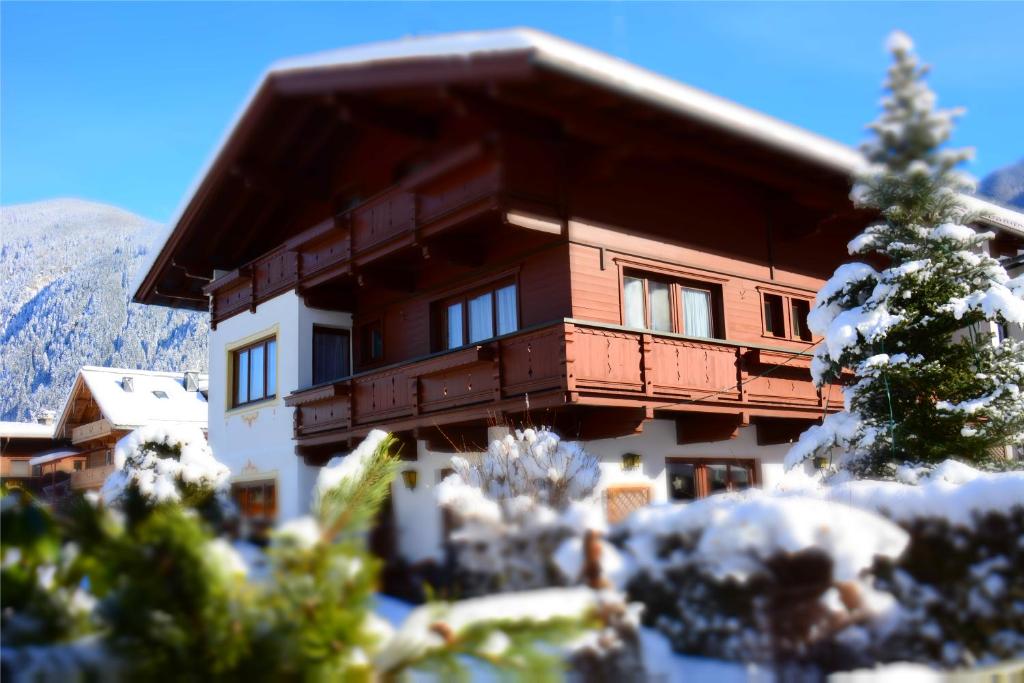 a large building with a balcony in the snow at Haus Tirolerland in Mayrhofen