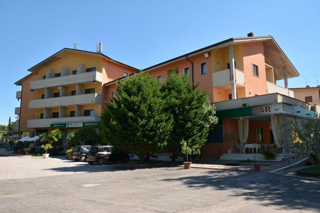 a large building with a parking lot in front of it at Hotel La Carica in Pastrengo