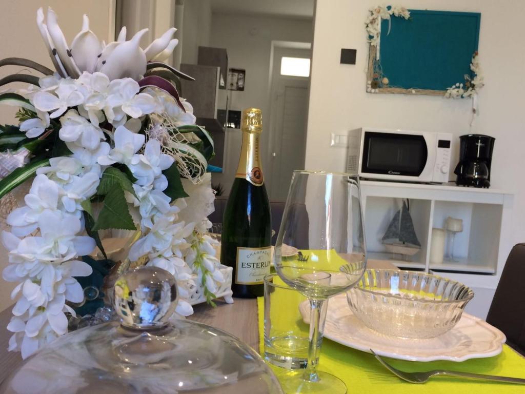 un tavolo con una bottiglia di vino e un vaso di fiori di Smeralda House a Viareggio