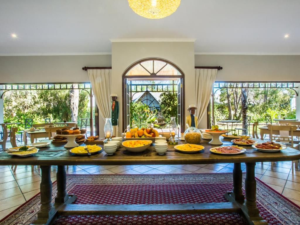 a table with a bunch of food on it at Hlangana Lodge in Oudtshoorn
